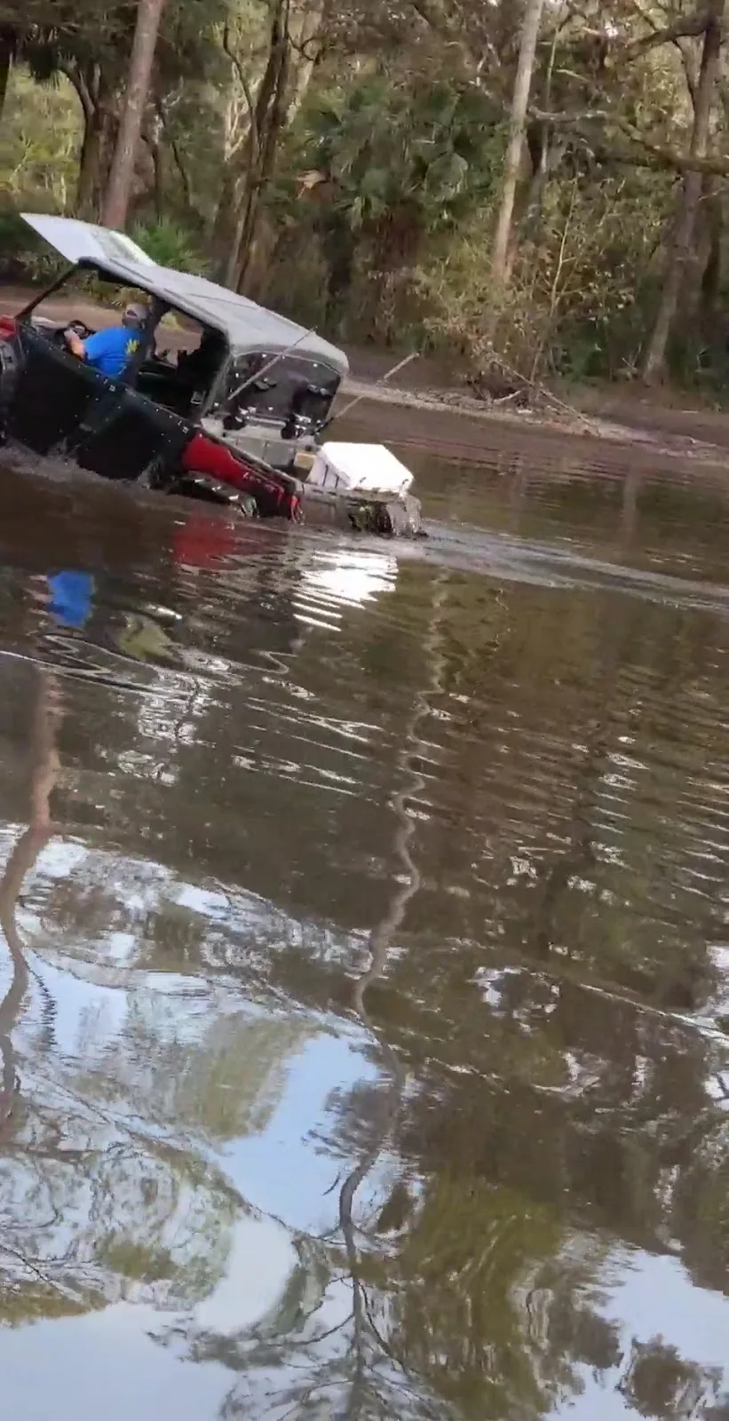 Side-by-side sitting door-deep in muddy water on a north Florida trail, the kind of ride that causes the electrical faults TMT Offroad diagnoses
