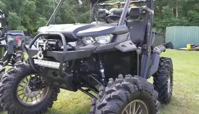 A lifted side-by-side on mud tires with a winch and LED light bar, built at TMT Offroad in Williston, FL